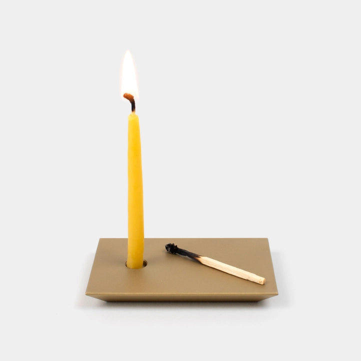 A yellow candle and a spent match